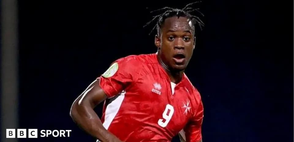 Joueur en maillot rouge courant sur le terrain