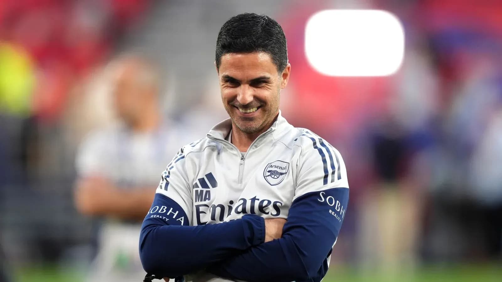 Entraîneur d'Arsenal souriant sur le terrain