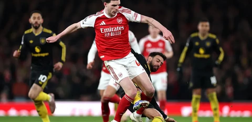 Joueur d'Arsenal chutant après un tacle de l'adversaire