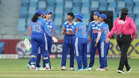 Équipe féminine de cricket discutant sur le terrain
