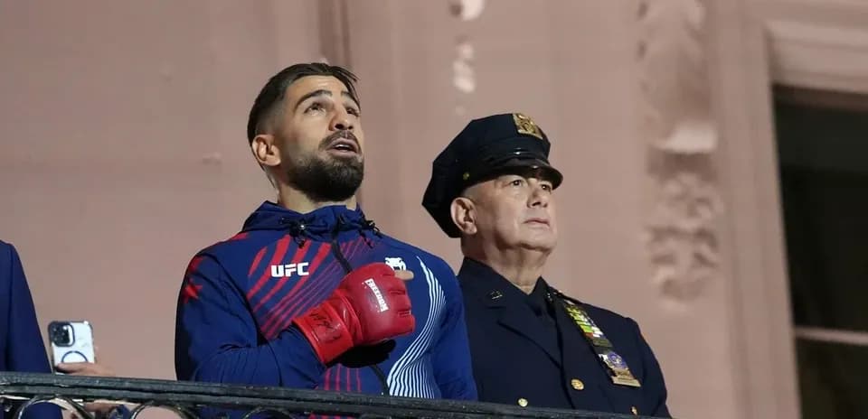 Athlete singing anthem with police officer nearby