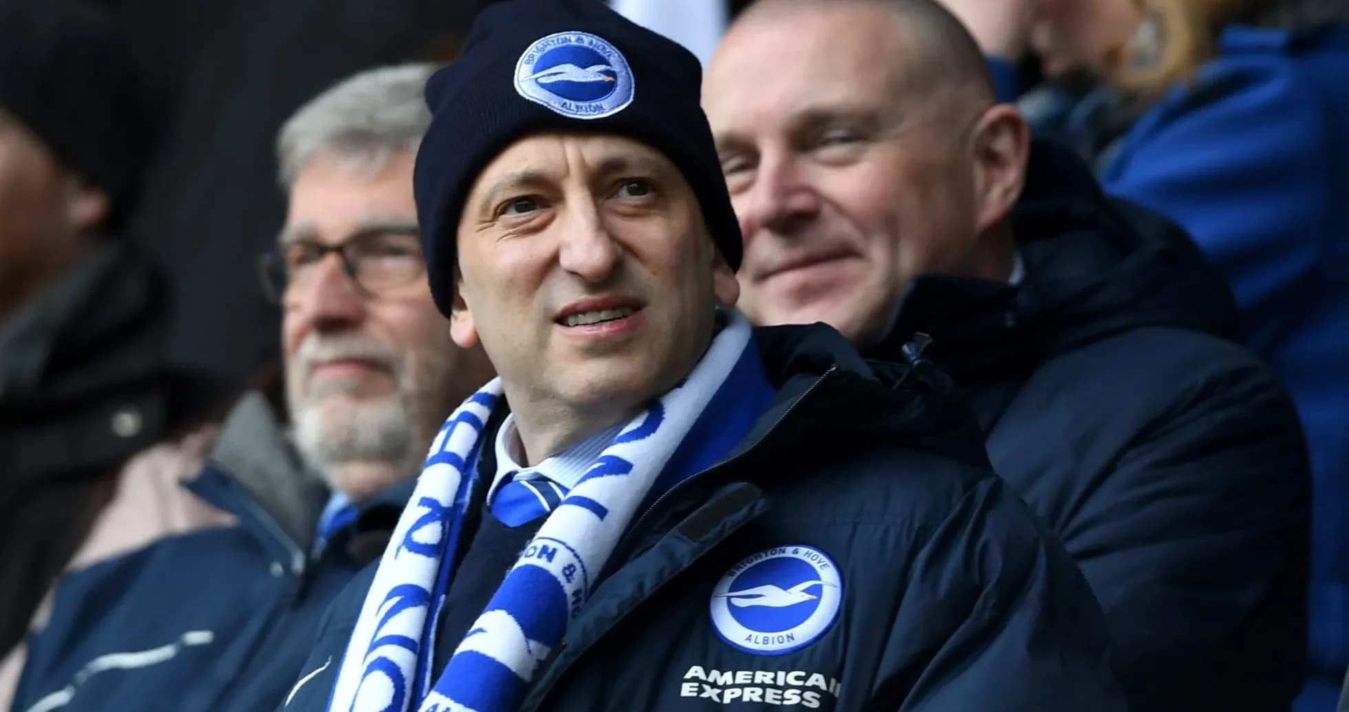 Homme portant un bonnet et une écharpe à un match