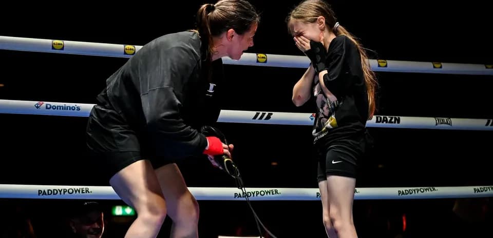 Boxeuse discutant avec une jeune fille sur le ring