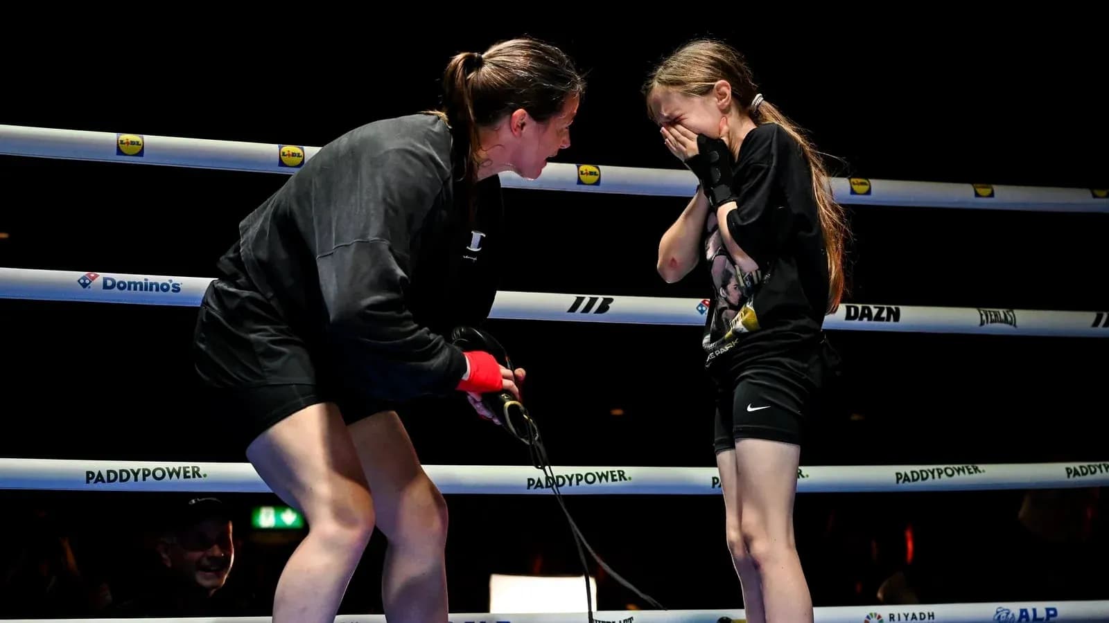 Boxeuse discutant avec une jeune fille sur le ring