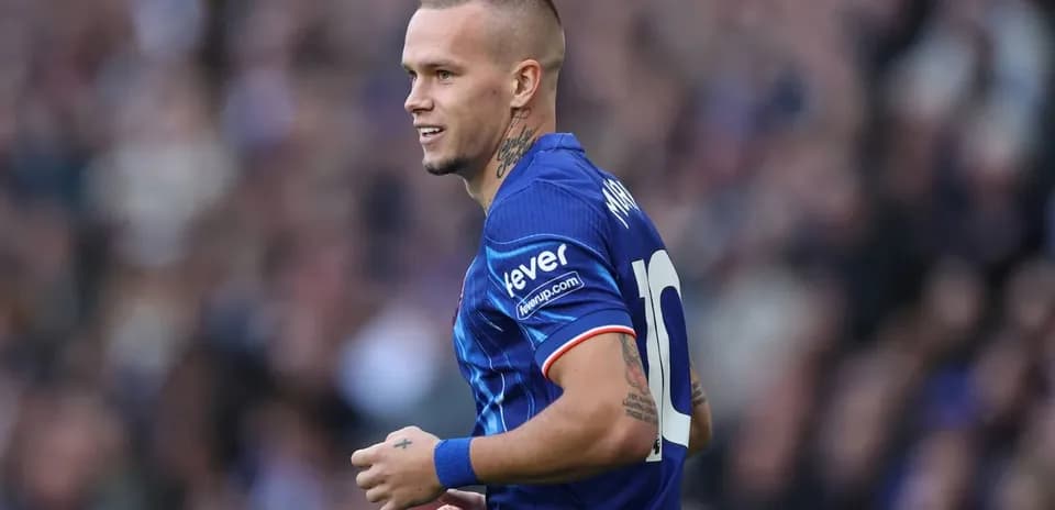 Joueur en maillot bleu souriant sur le terrain