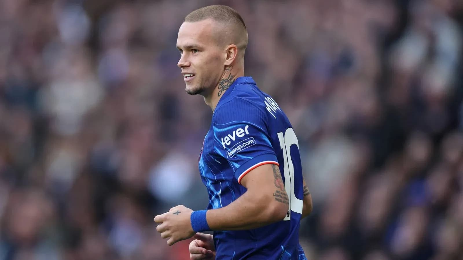 Joueur en maillot bleu souriant sur le terrain
