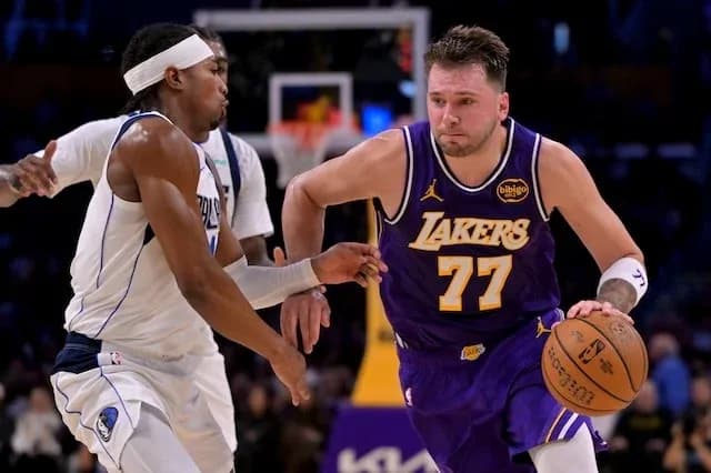 Joueur des Lakers dribblant face à un défenseur