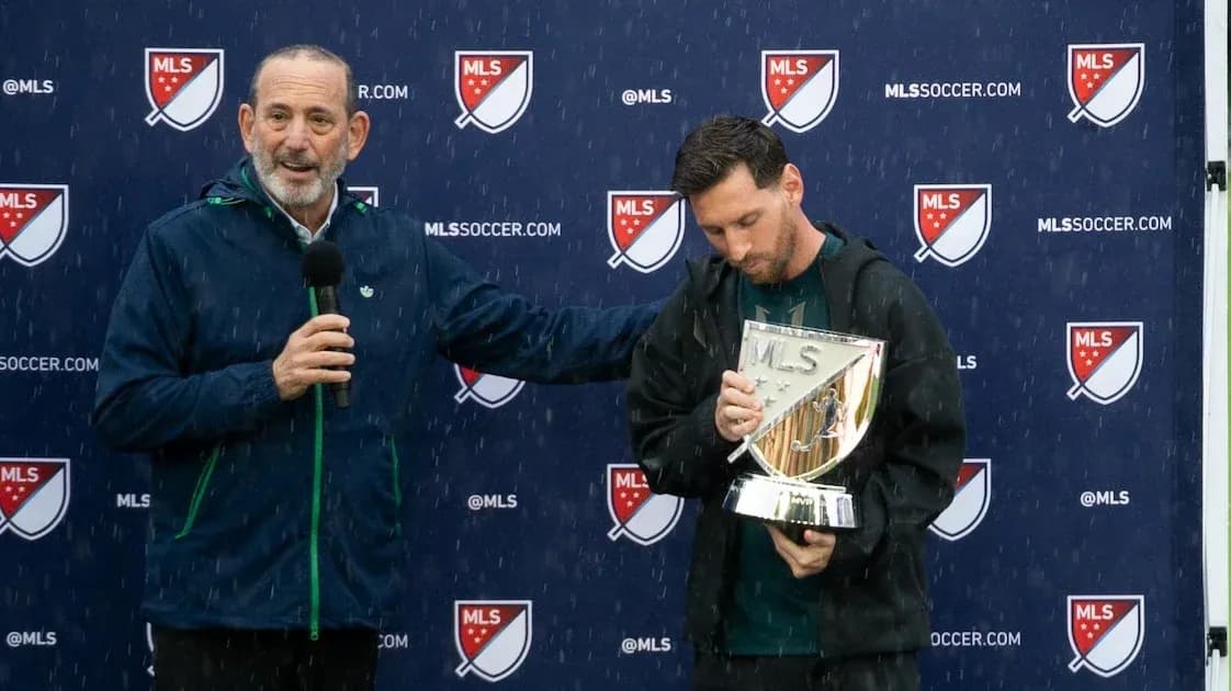 Lionel Messi holding MLS trophy during press event
