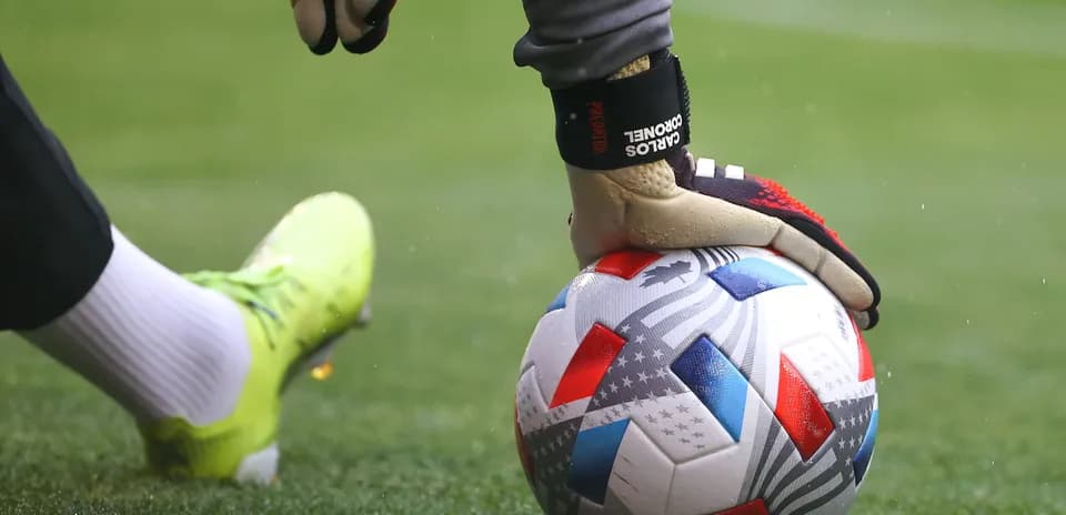 Gardien de but tenant un ballon sur le terrain
