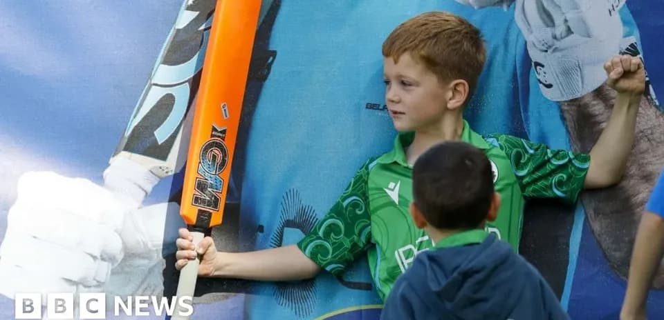 Enfant brandissant une batte de cricket devant une affiche