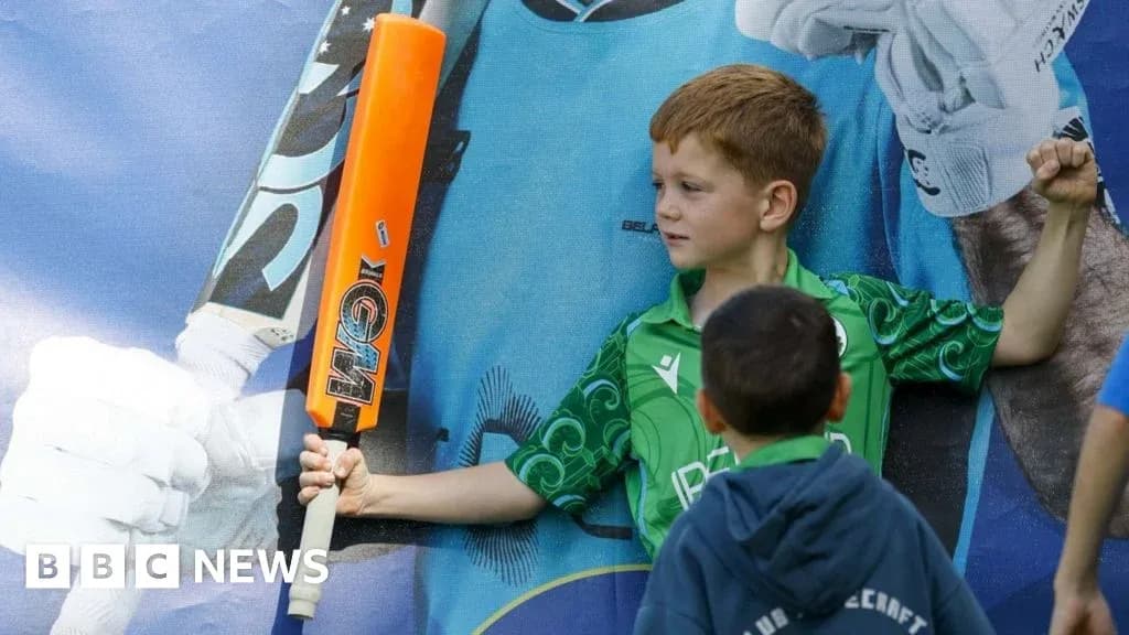 Enfant brandissant une batte de cricket devant une affiche