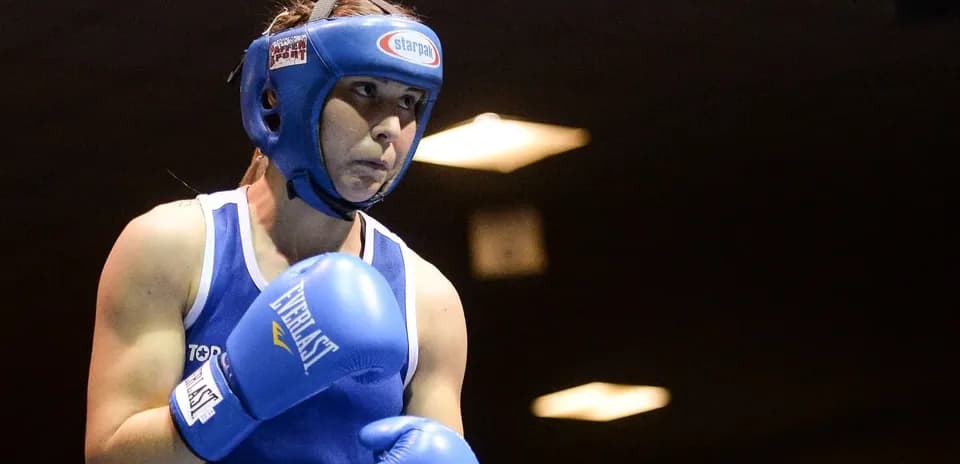Boxeuse en position d'attente avec gants bleus