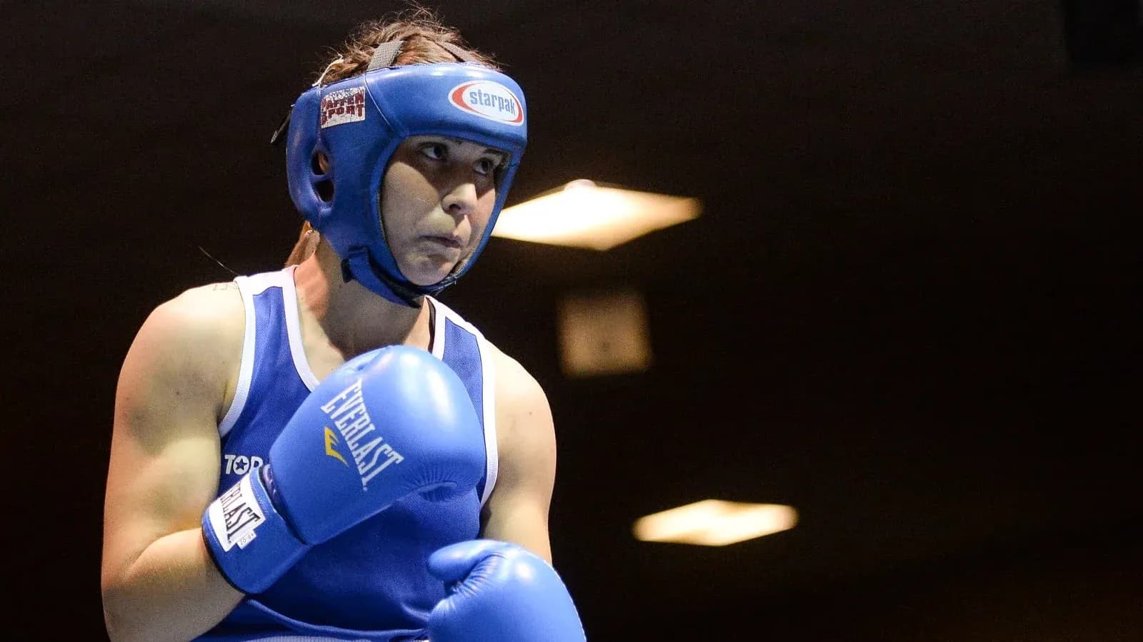 Boxeuse en position d'attente avec gants bleus