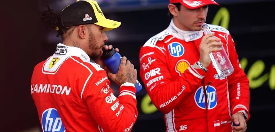 Deux pilotes en tenue de course buvant de l'eau