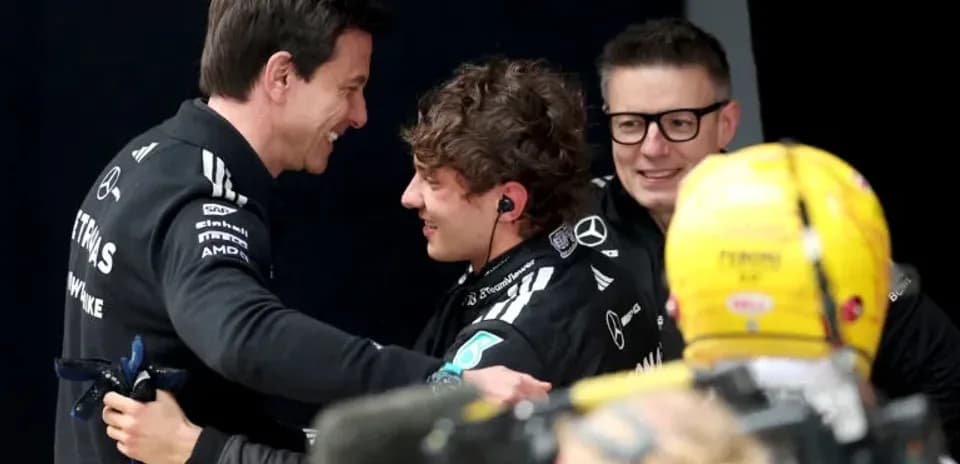 Trois membres de l'équipe Mercedes célébrant ensemble