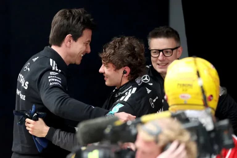 Trois membres de l'équipe Mercedes célébrant ensemble