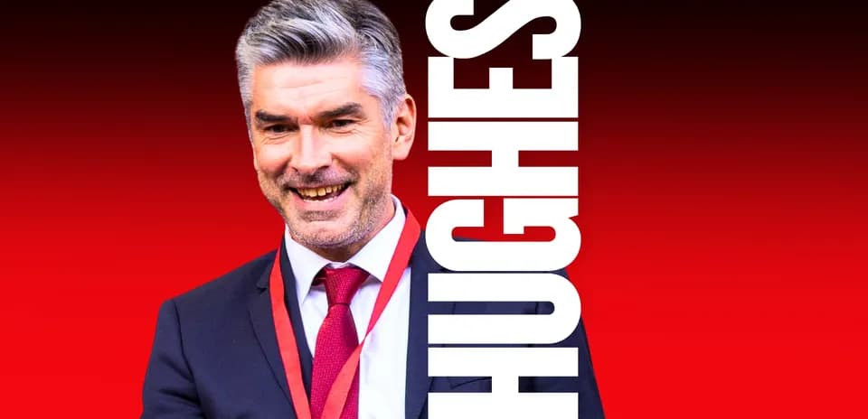 Homme souriant en costume avec un médaillon rouge