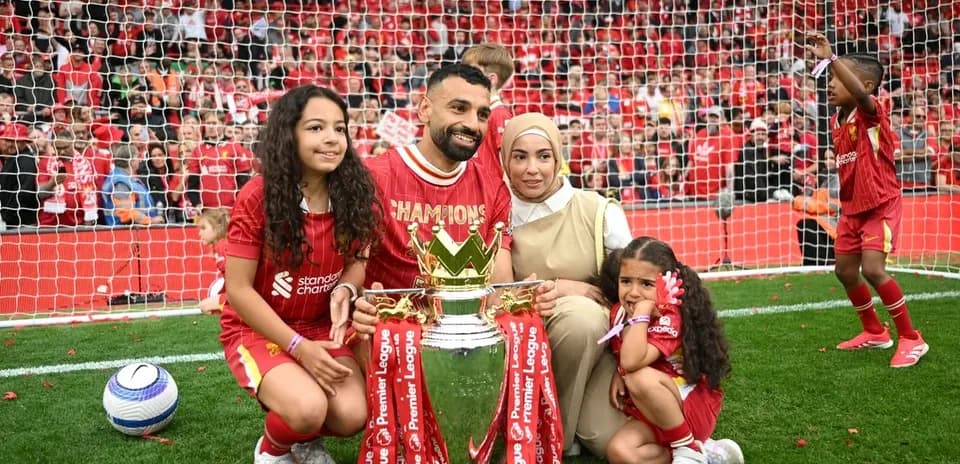 Joueur avec sa famille posant devant le trophée