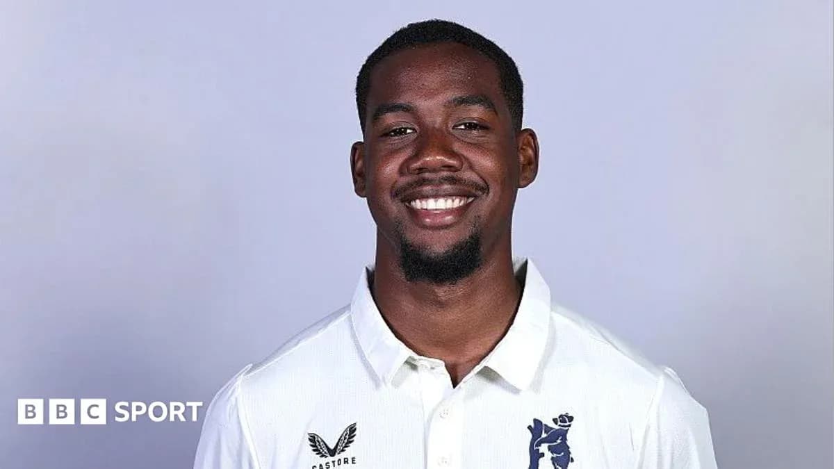 Joueur souriant en tenue de cricket avec logo