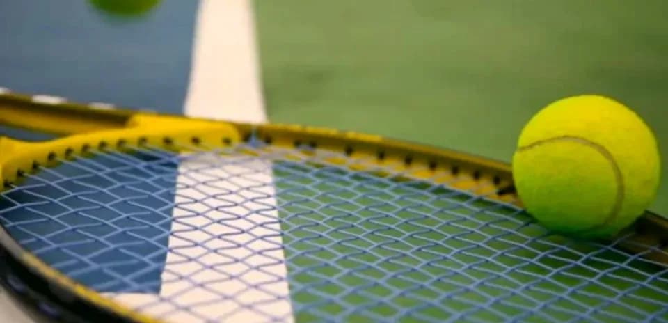 Balle de tennis sur une raquette sur court