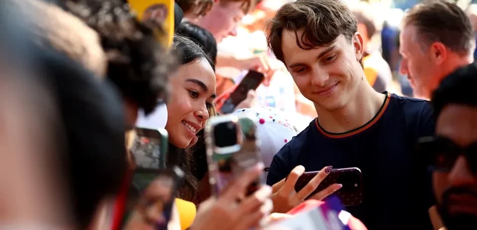 Jeune homme et femme prenant un selfie en foule