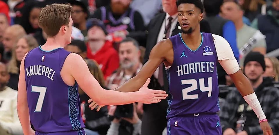 Joueurs des Hornets se serrant la main sur le terrain