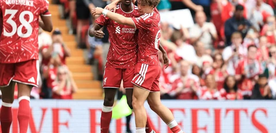 Deux joueurs de Liverpool s'enlaçant sur le terrain