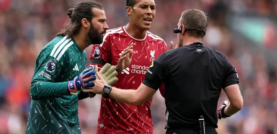 Joueurs de Liverpool discutant avec l'arbitre