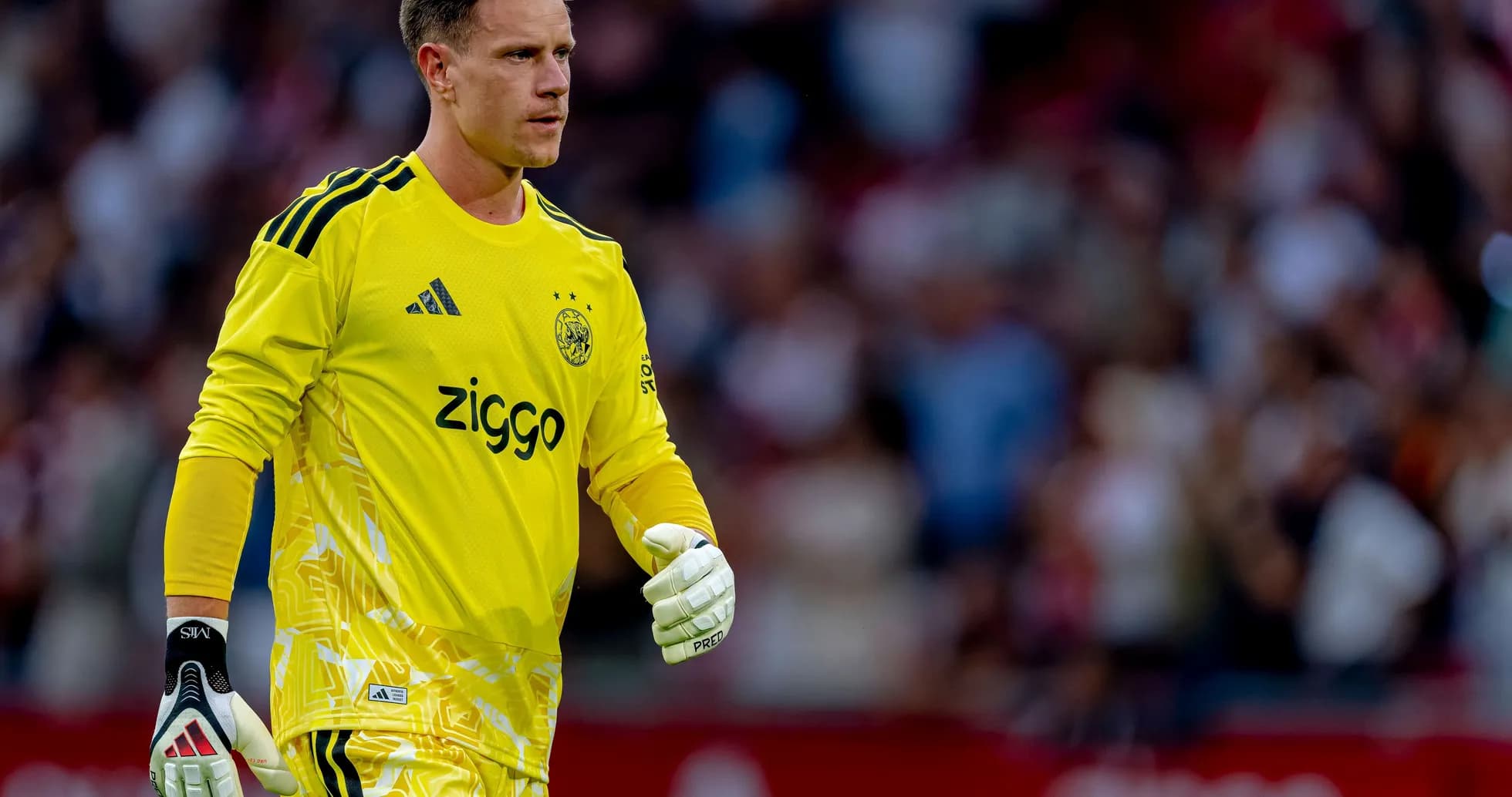 Gardien de but d'Ajax en tenue jaune sur le terrain
