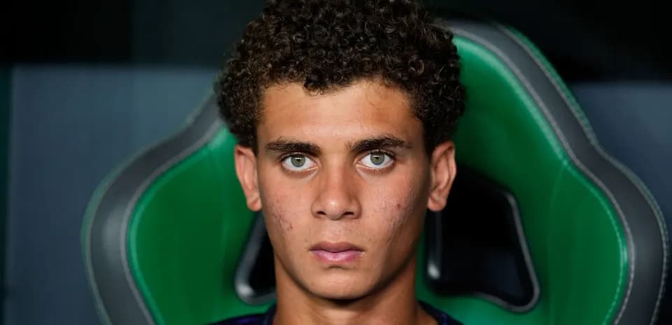 Jeune joueur assis sur un fauteuil vert