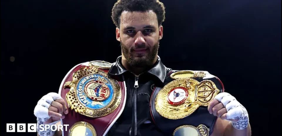 Boxeur tenant des ceintures de champion sur le ring