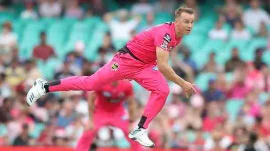 Joueur en train de lancer lors d'un match de cricket