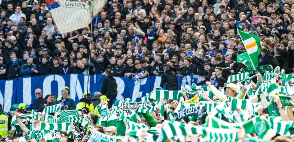 Supporters waving scarves in a football stadium