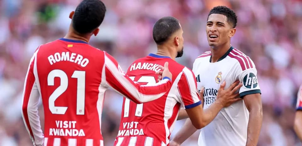 Joueurs d'Atletico Madrid confrontant un joueur du Real Madrid