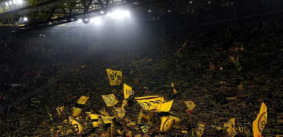 Supporters waving flags in Borussia Dortmund stadium