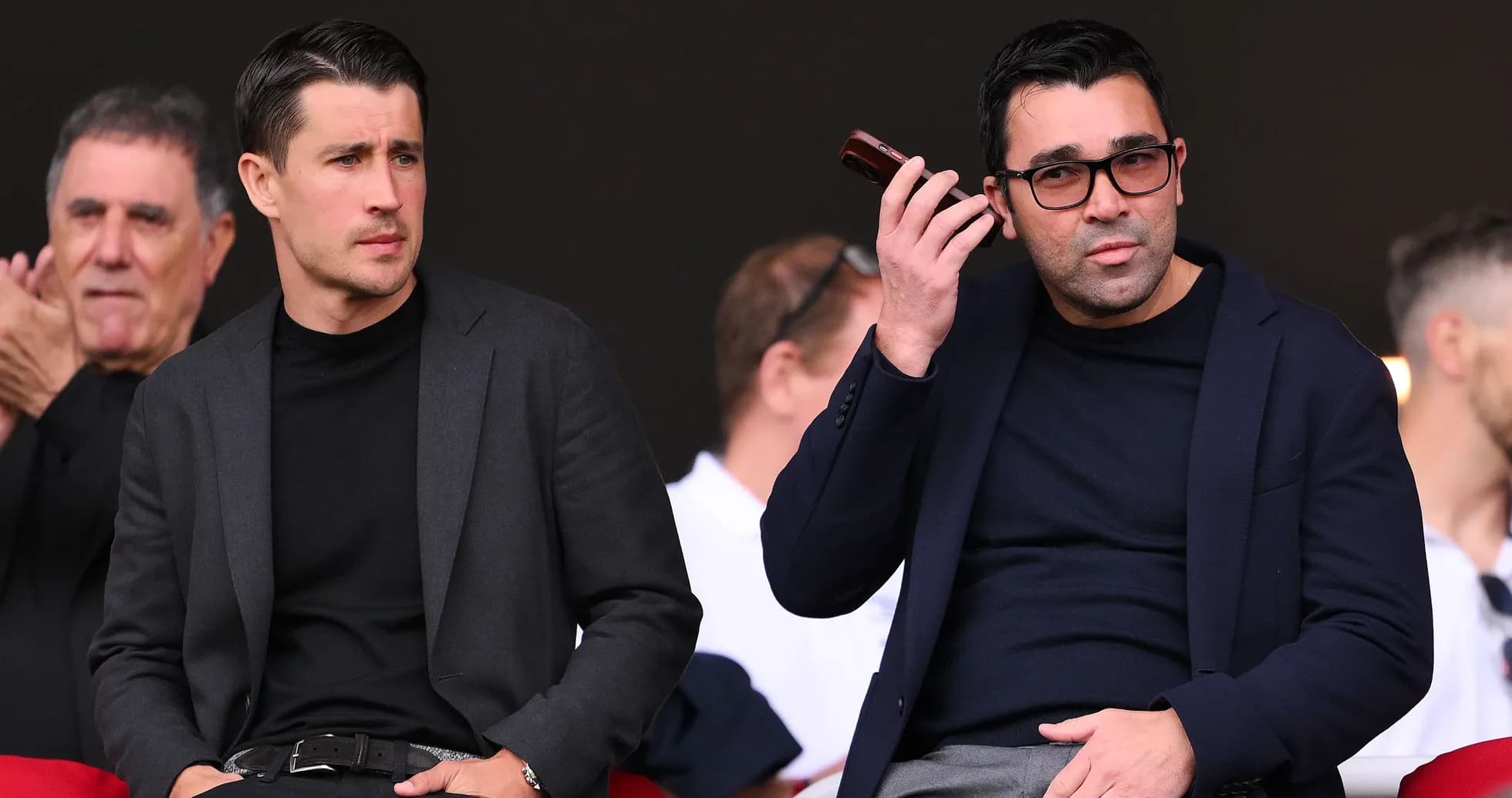 Deux hommes assis dans les tribunes, observant le match Deux hommes assis dans les tribunes, observant le match