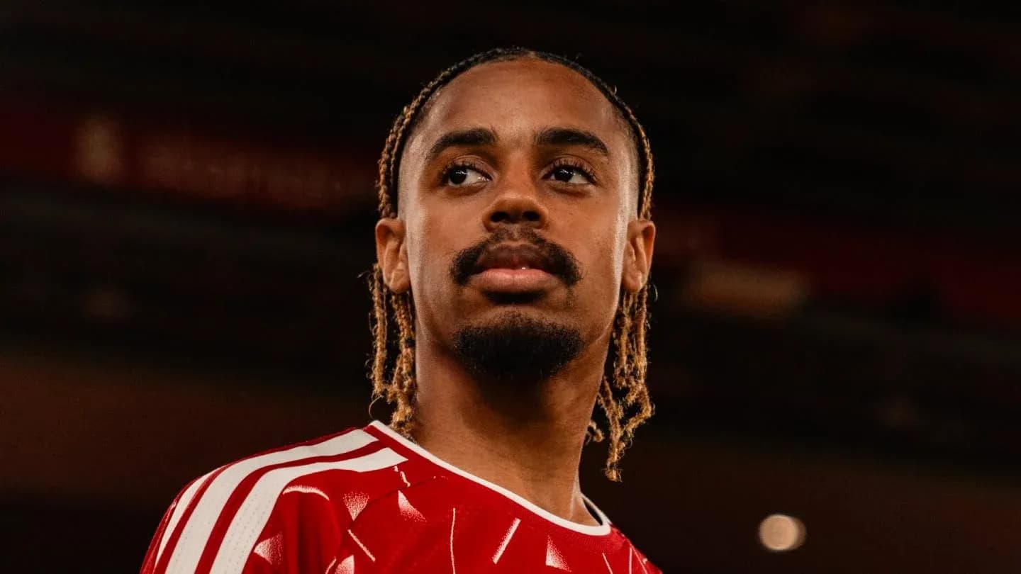 Joueur avec maillot rouge regardant au loin Joueur avec maillot rouge regardant au loin