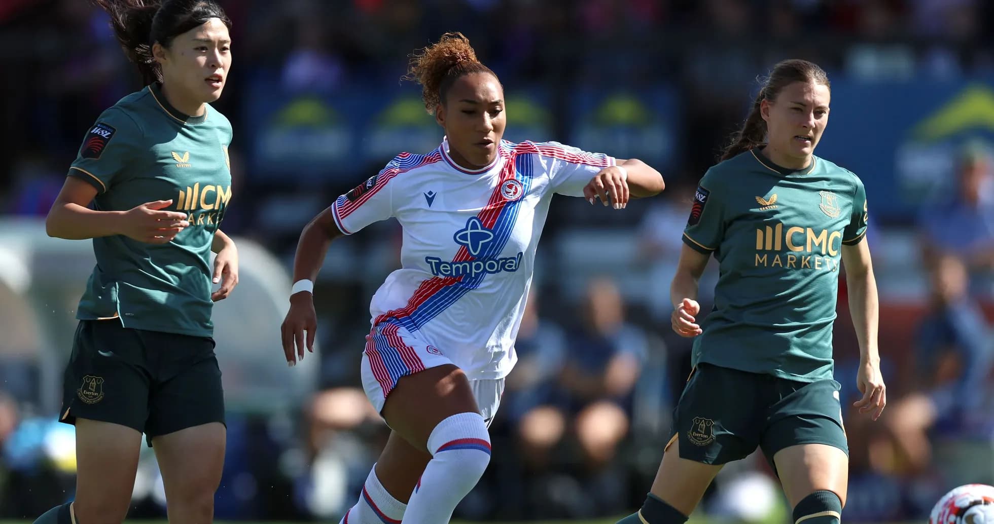 Joueuse dribblant entre deux adversaires sur le terrain Joueuse dribblant entre deux adversaires sur le terrain