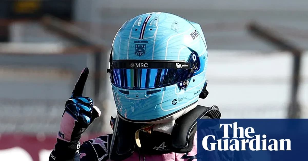Pilote de Formule 1 avec un casque bleu levant un doigt Pilote de Formule 1 avec un casque bleu levant un doigt