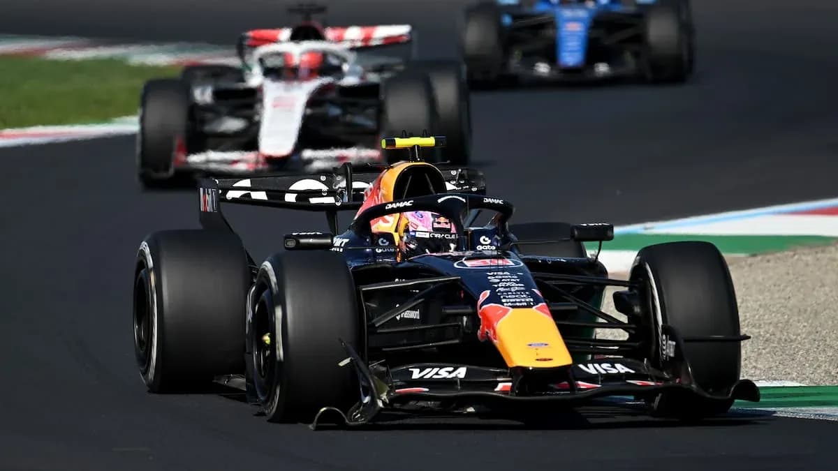 Voiture de F1 en course avec deux autres voitures en arrière-plan Voiture de F1 en course avec deux autres voitures en arrière-plan