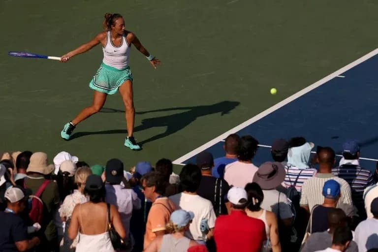 Joueuse de tennis frappant une balle devant le public Joueuse de tennis frappant une balle devant le public