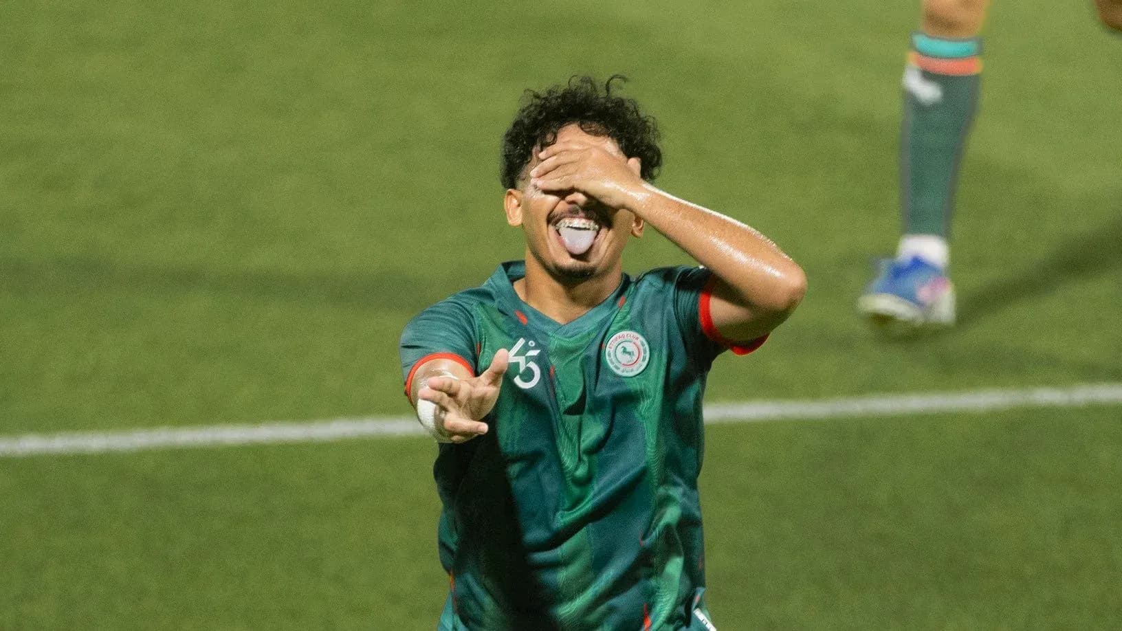 Joueur célébrant un but sur le terrain de football Joueur célébrant un but sur le terrain de football