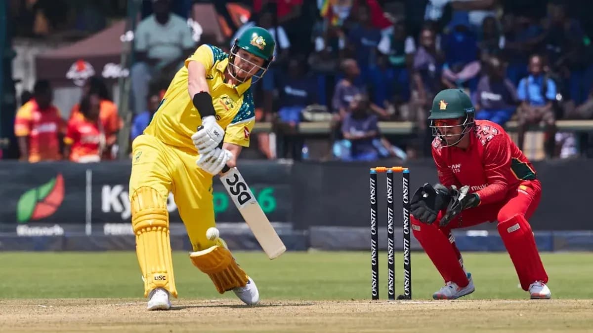 Batsman playing shot while wicketkeeper prepares to catch Batsman playing shot while wicketkeeper prepares to catch