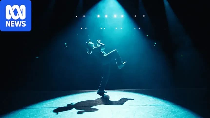 Danseur en pleine performance sur scène éclairée Danseur en pleine performance sur scène éclairée