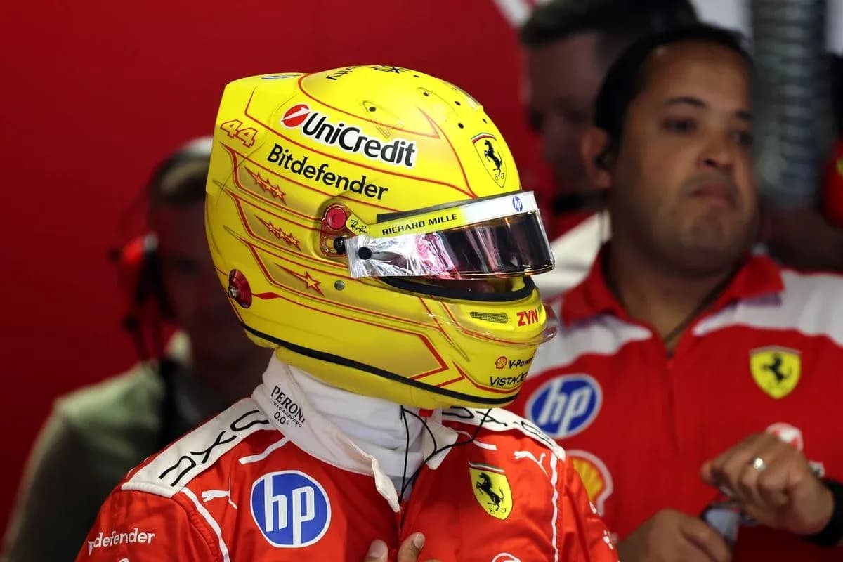 Pilote en combinaison Ferrari avec casque jaune dans les stands Pilote en combinaison Ferrari avec casque jaune dans les stands