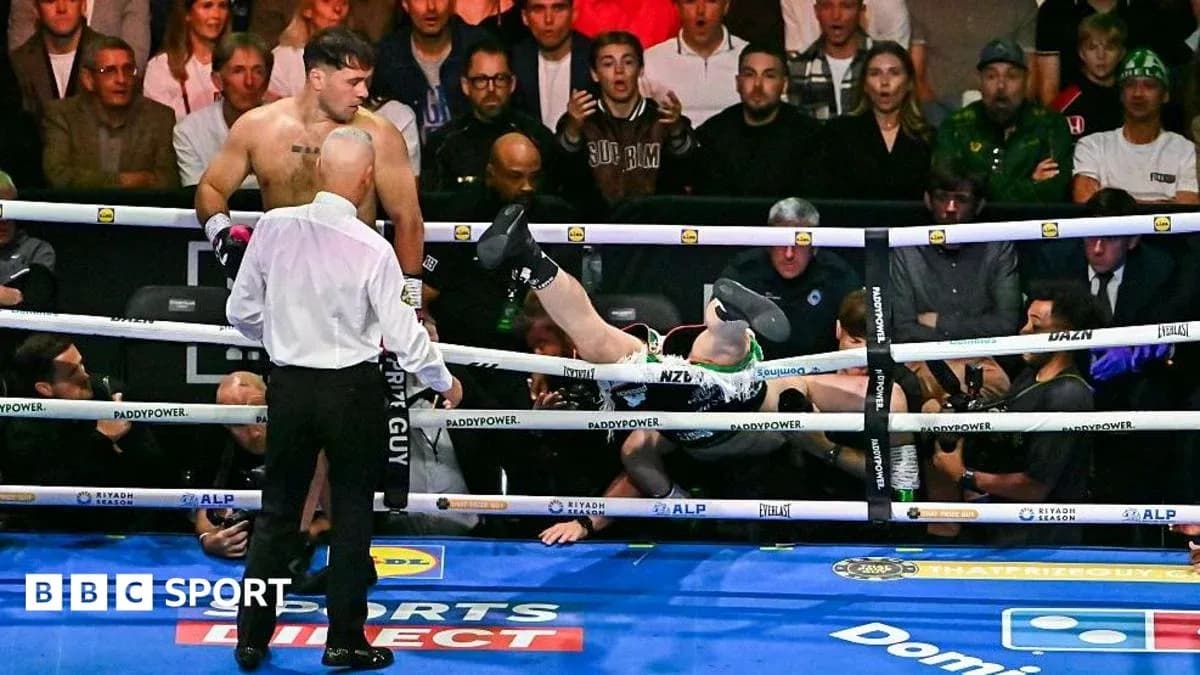 Boxer knocked out with legs over ropes in ring Boxer knocked out with legs over ropes in ring