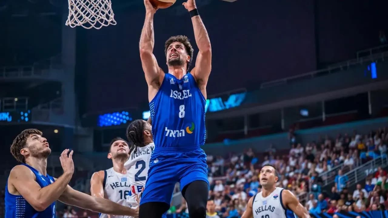 Joueur israélien dunkant pendant un match de basket Joueur israélien dunkant pendant un match de basket