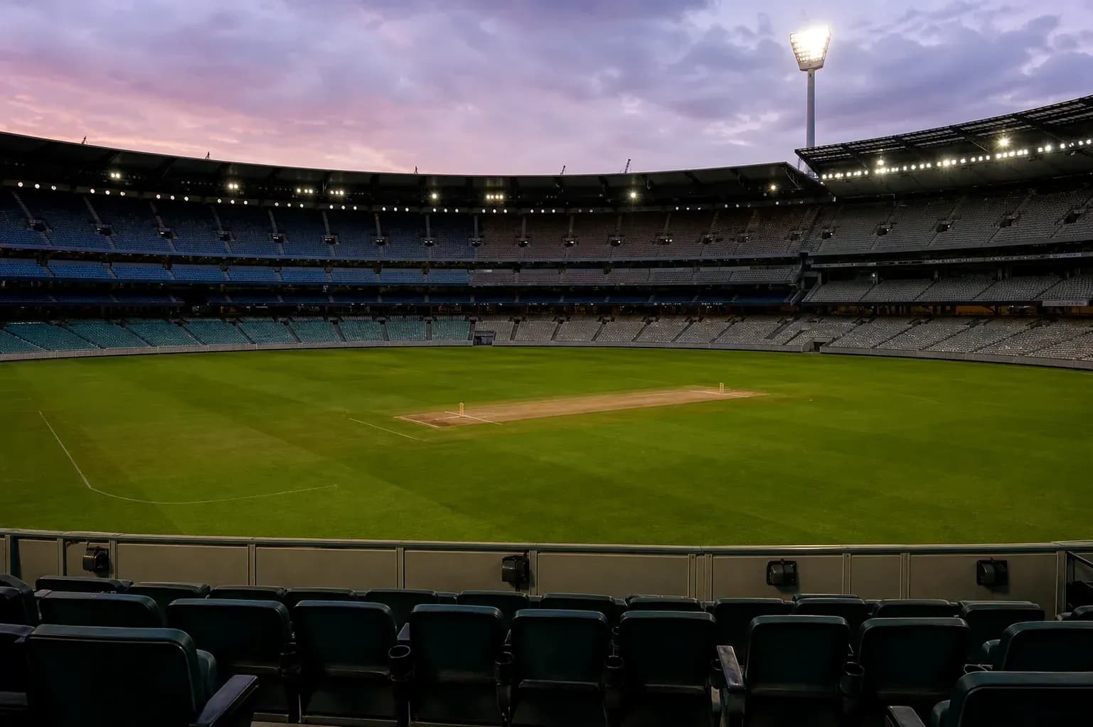 Stade de cricket vide avec terrain au crépuscule Stade de cricket vide avec terrain au crépuscule