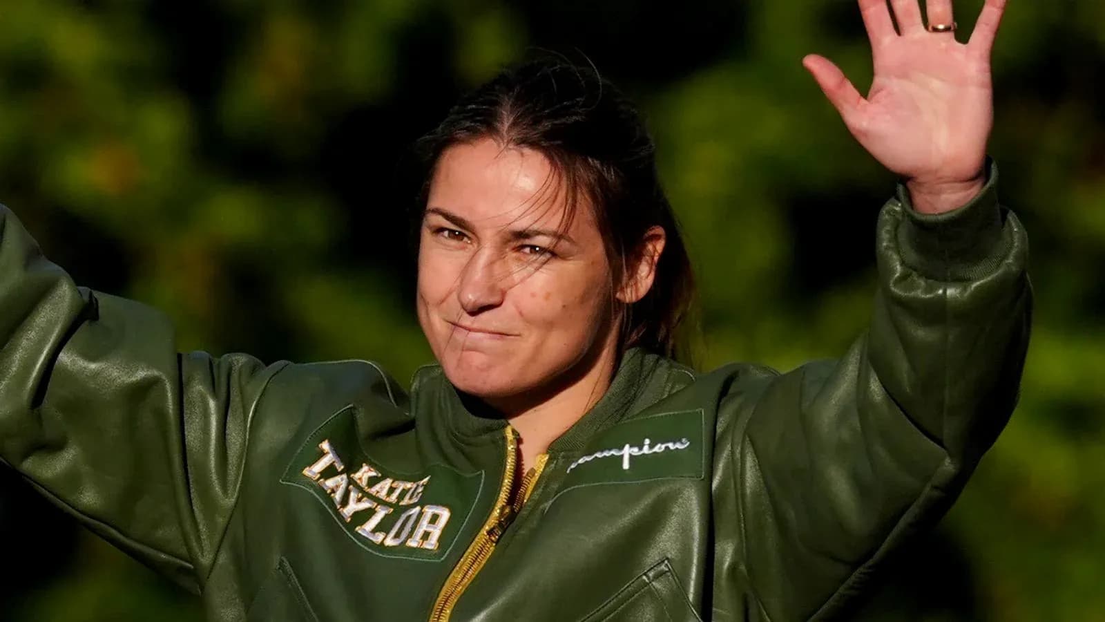 Athlete saluting while wearing a green jacket Athlete saluting while wearing a green jacket