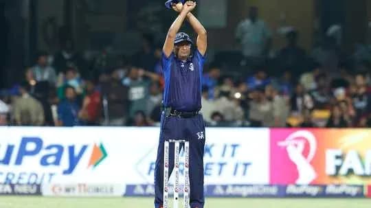 Arbitre levant les bras pendant un match de cricket Arbitre levant les bras pendant un match de cricket